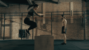 A Woman Jumping High At A Crossfit Gym