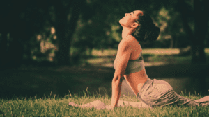 A woman outdoor in nature doing yoga and remaining in peace with herself and the world.