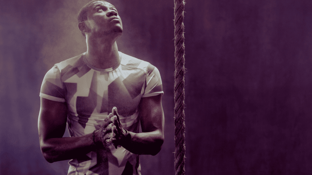 A CrossFitter watching at a climbing rope 