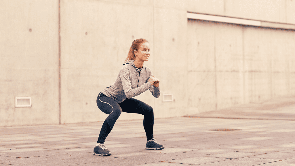 A Woman Performing Squats Outdoors. 