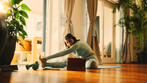 A Woman Stretching At Home And Watching Online Fitness Class