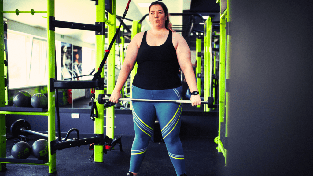 An Overweight Woman Standing With A Barbel 