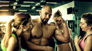 A bodybuilde Surrounded by 3 Women 