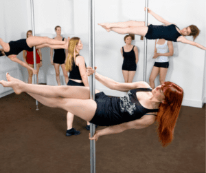 women in pole fitness class practising 