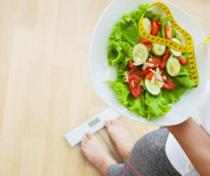 a woman chacking her weight while holding a salad 