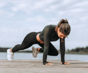 a woman in black doing core workout outdoors