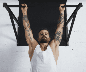 a man with many tattoos doing pull ups 