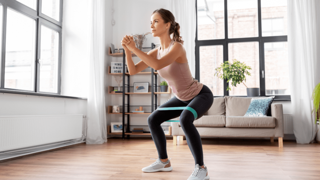 a woman at her apartment doing a resistance bands glutes workout 