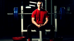 A Man Sitting On A Bench Press Photo 