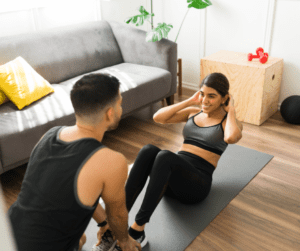 a man helps a woman for her abs workout 