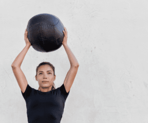 a woman holding a medicine ball