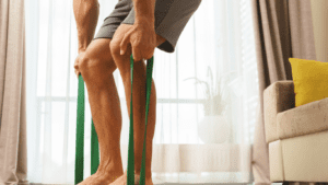 a man performing a dead lift with a resistance band at home