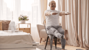 an old man doing yoga chair exercises at home 