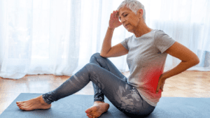 an elder woman on a yoga mat having a lower back pain 