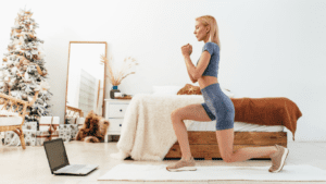 A blond woman in blue doing back lunges exercise at home