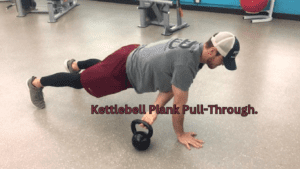 A man performing Kettlebell Plank Pull-Through Exercise 