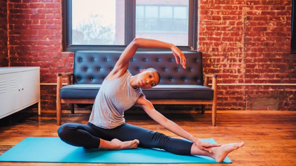 A Woman Doing Yoga for muscle recovery on a yoga mat 