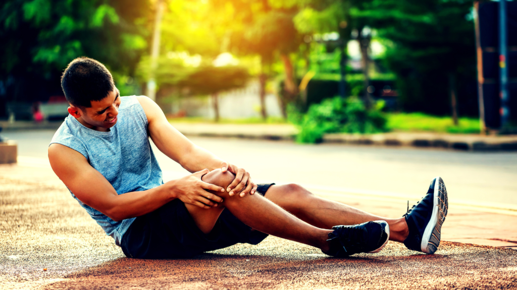 A Photo Showing An Injured Runner In Pain Sitting On The Road