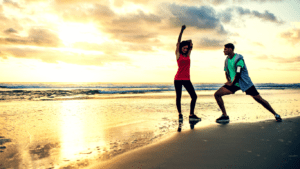 A Couple Exercising On The Beach In The Early Morning 