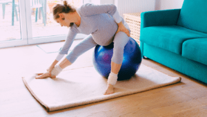 Pregnant Woman Stretching With Yoga Ball as a yoga ball exercise for pregnancy 