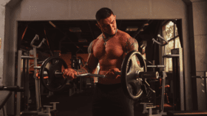 A Bodybuilder doing curls for biceps in the gym