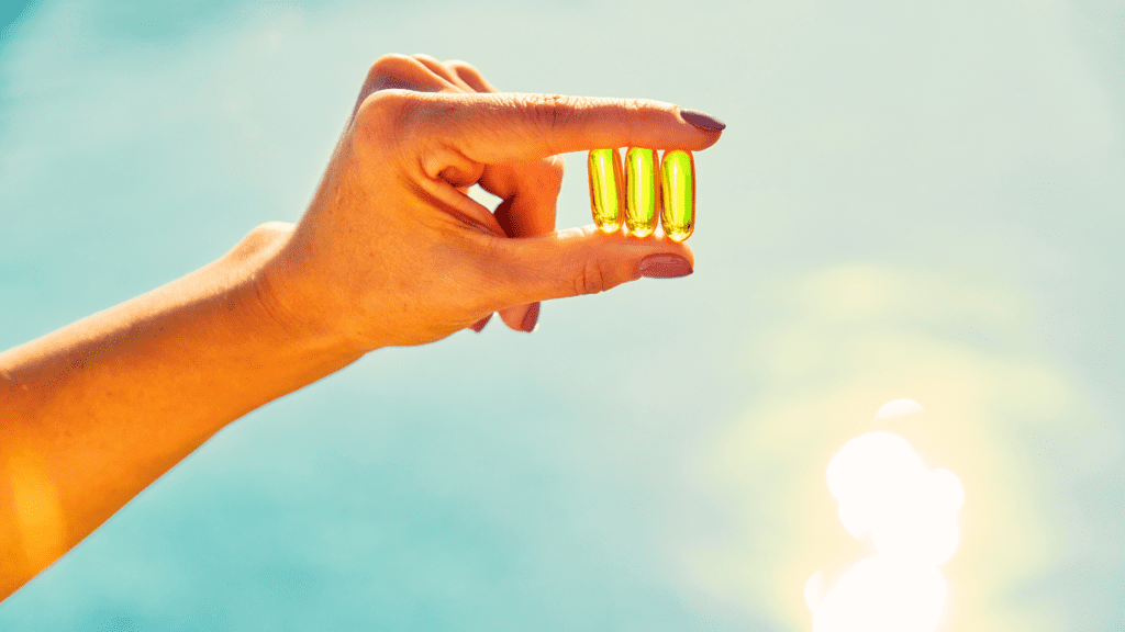 A Hand Holding 3 Tablets Of Vitamin D