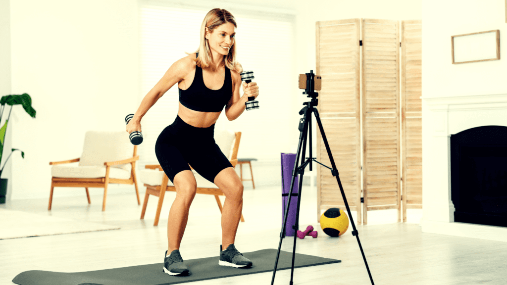 A Woman filming herself exercising :How to Start an Online Fitness Coaching Business