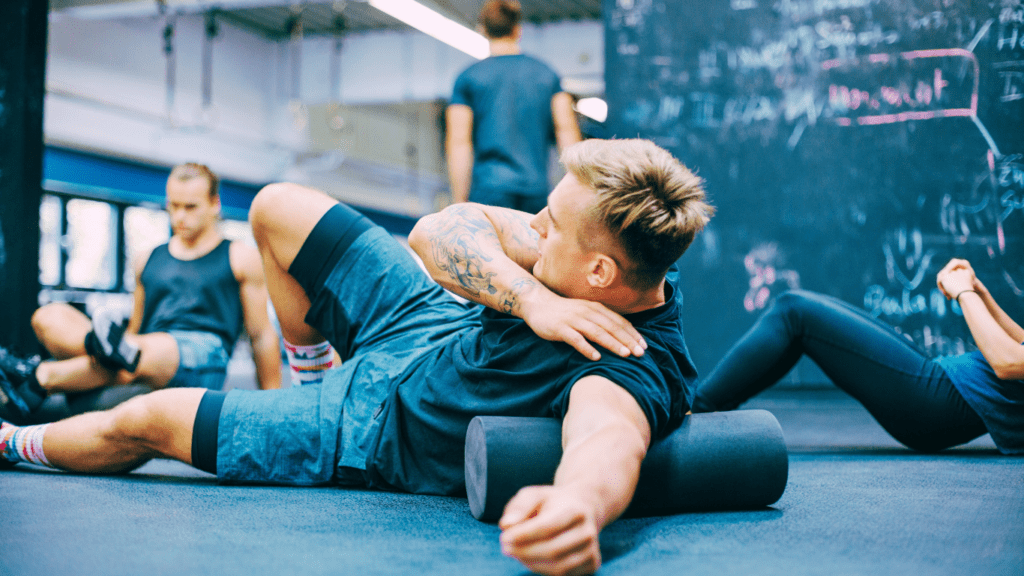 A Male Athlete Using Foam Roller 