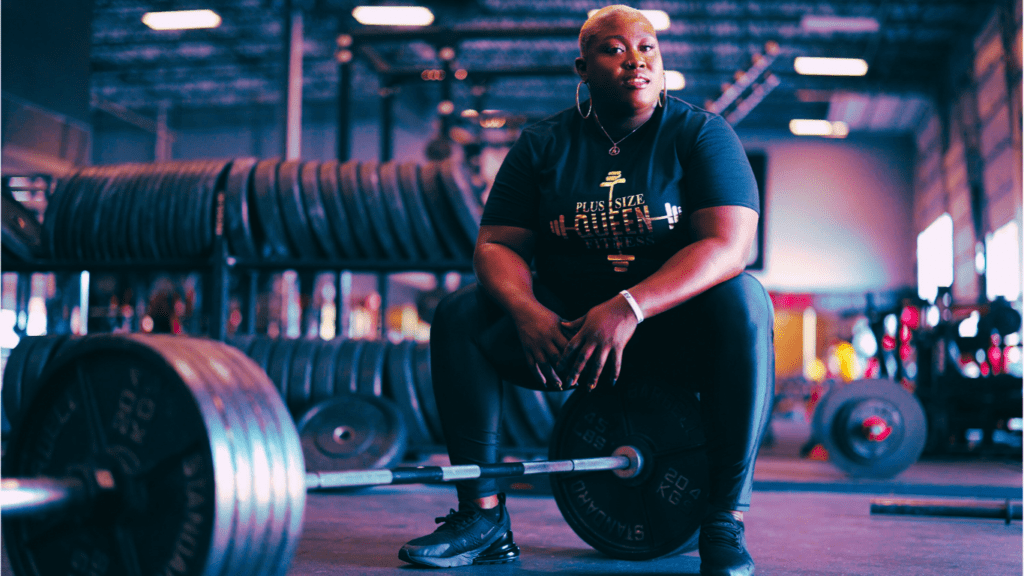 A Woman Powerlifter Sitting On A Lot Of Weights 