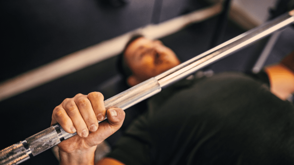 A Man Holding Barbel On A Bench Press Representing The Article how to bench press more weight