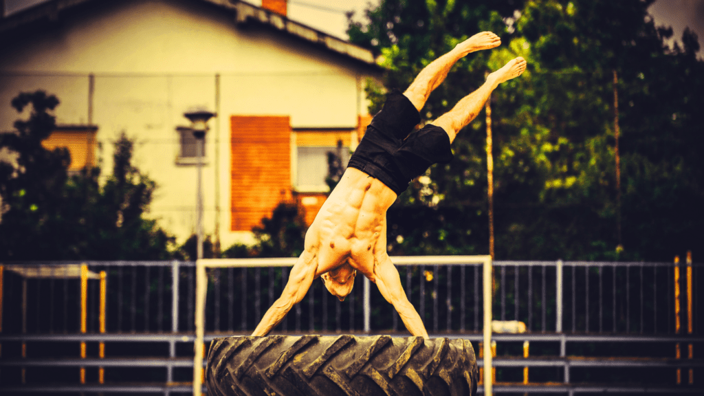 best calisthenics workout for beginners A Man Doing Hand Stand On A Tire 