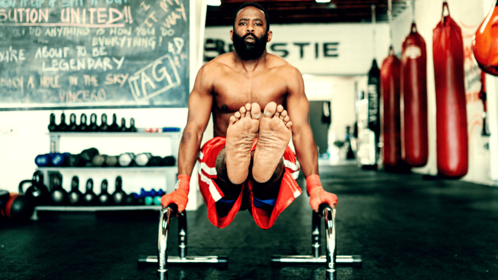 A Muscular Man Exercising On Parallel Bars