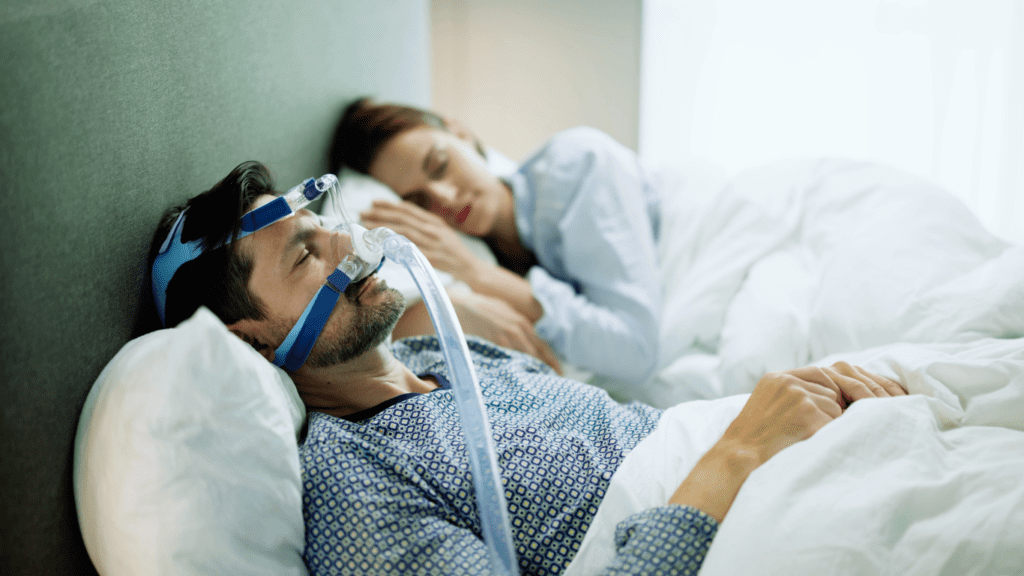 A Man Sleeping with Breathing Machine for Sleep Apnea 