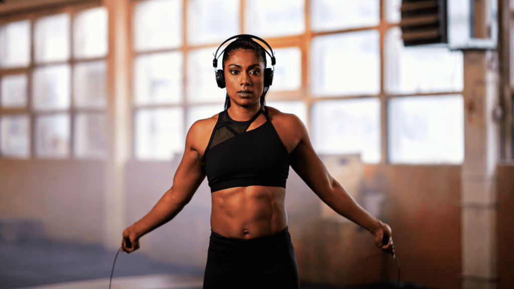 A pretty fit woman training with a skipping rope at the gym 