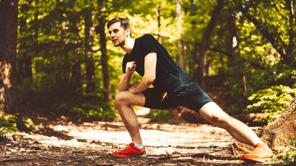 Man stretching outdoor as a way of how to reduce muscle soreness after leg day