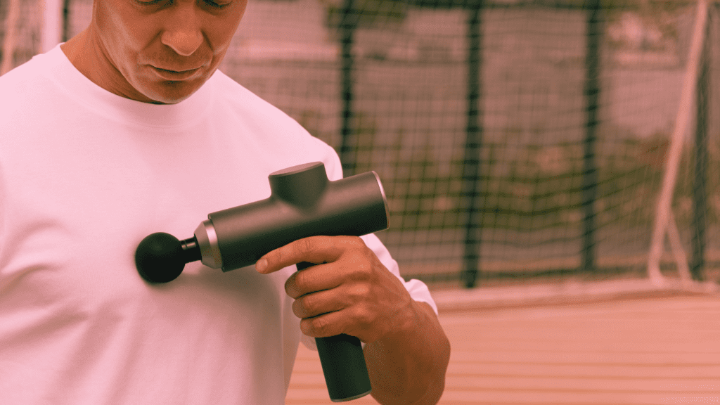 A Man Holding A Tool For Massages And Massaging Himself