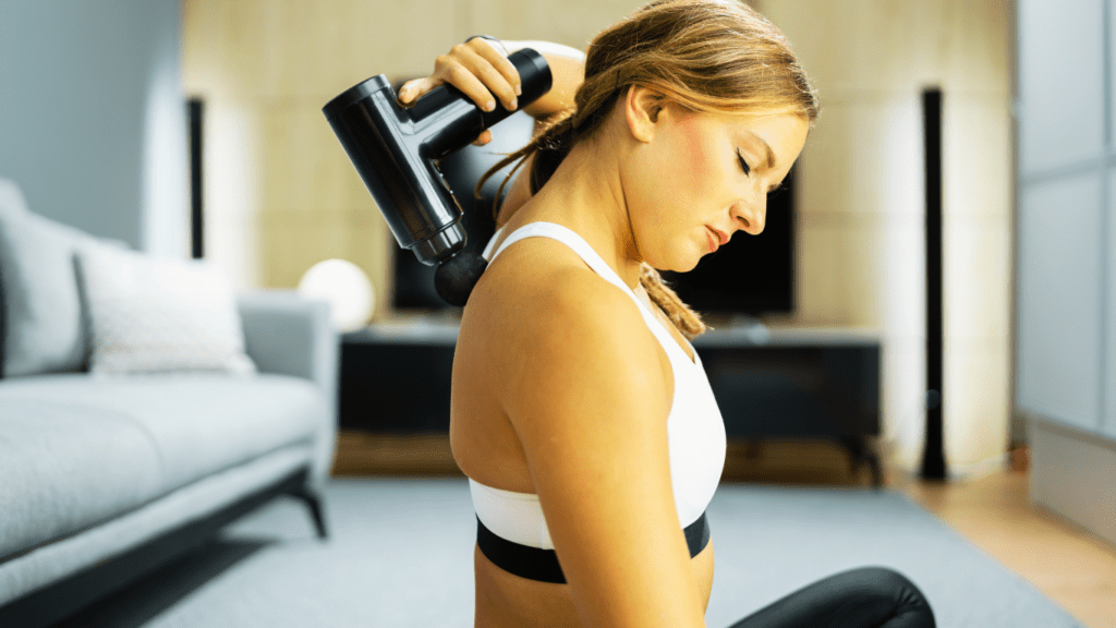 A Woman Using A Massage Gun For Recovery 