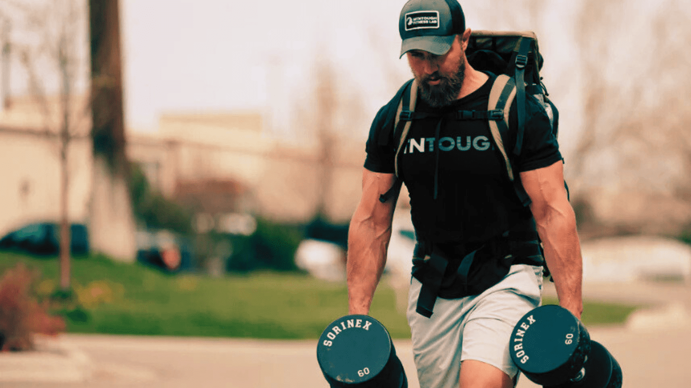 A Man With A Ruck And Two Dumbbells