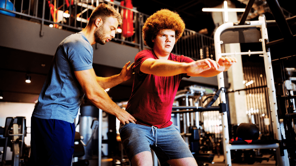Personal trainer showing how to perform compound lift- squad 